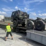 Contractors assigned to the 405th Army Field Support Brigade upload another Army Prepositioned Stocks-2 equipment piece onto a transport truck using the new Rapidly Available Interface for trans-Loading, or RAIL, modular ramp system. The Rail system is helping to expedite the movement of more than 5,000 APS-2 vehicles and equipment pieces. (Courtesy photo)